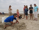 Before the release, Mark Landrum, Master Sculptor from SandFest, teaches kids how to make sand turtles.